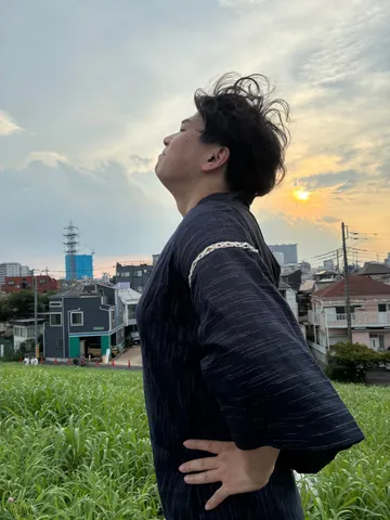 夕暮れの草地に立っているところ