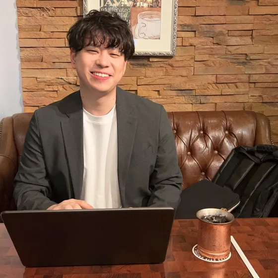 小澤玄。カフェでノートPCに向かっているところ